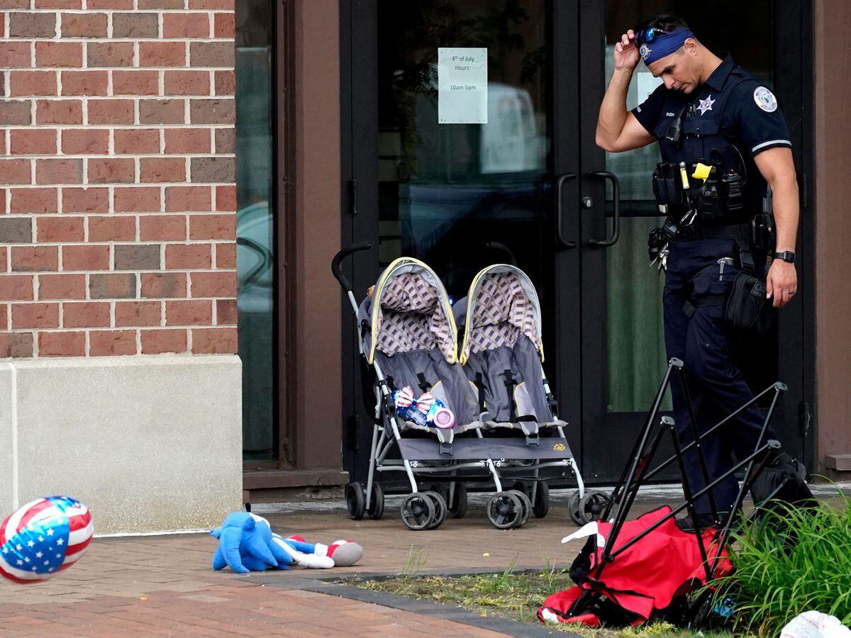 A police officer reacts as he walks in downtown Highland Park