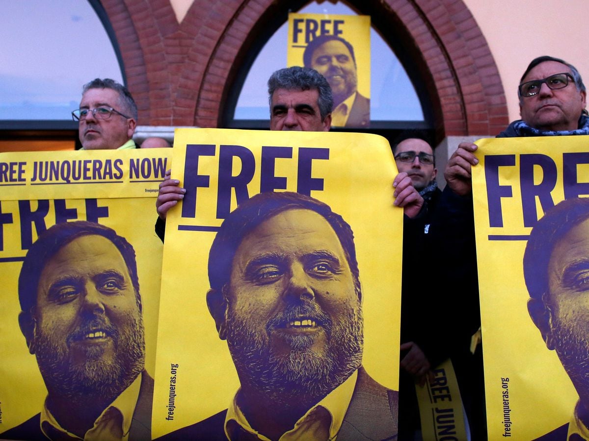 Demonstrators hold banners with the image of former Catalan vice-president Oriol Junkras