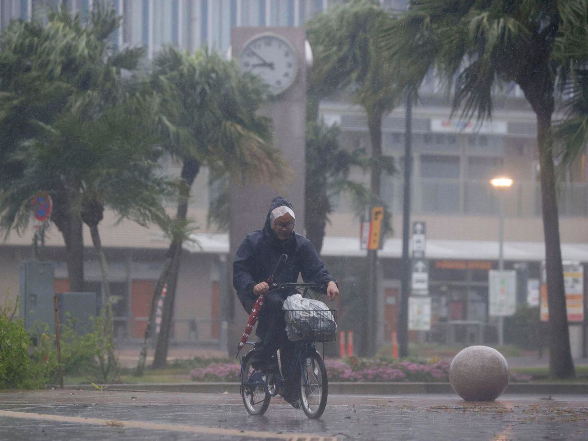 A man riding a bicycle in the rain in Miyazaki, southern Japan