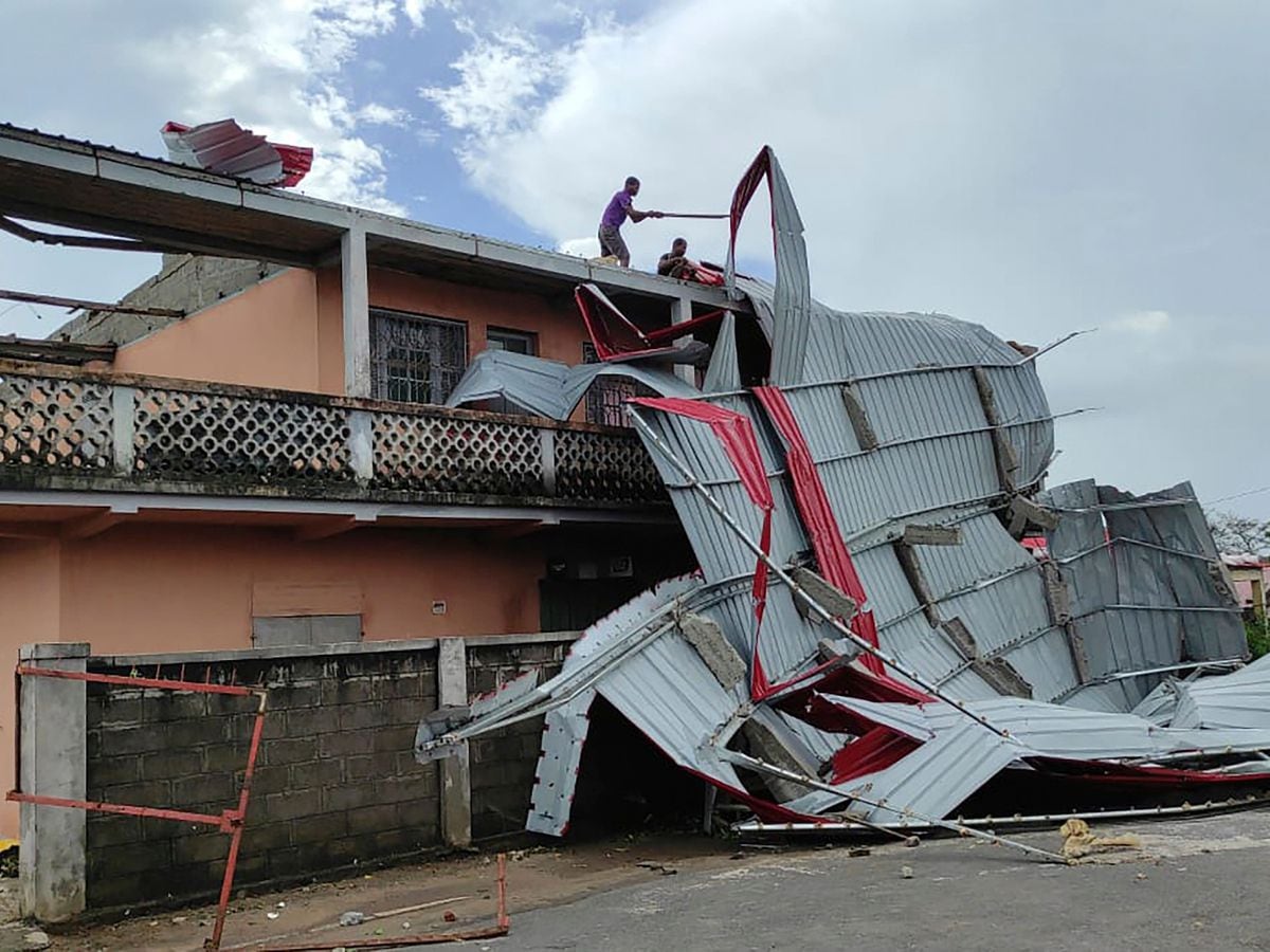 People work on a damaged building in Mananjary district, Madagascar