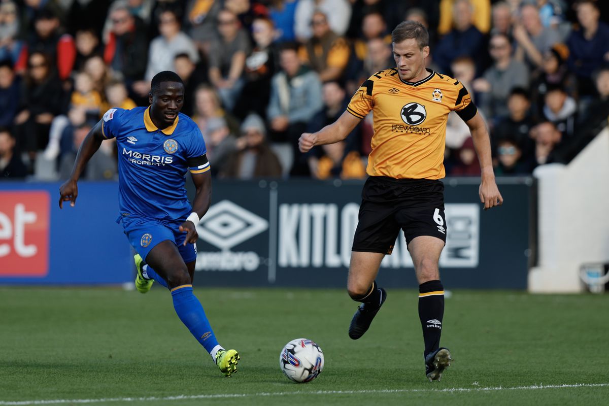 Dan Udoh of Shrewsbury Town and Ryan Bennett of Cambridge United battle for the ball (AMA)