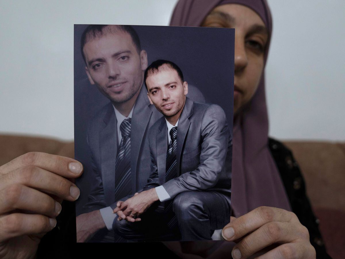 Dalal, wife of Israeli Palestinian prisoner Khalil Awawdeh, displays pictures of him at his home in the West Bank town of Idna, west of Hebron