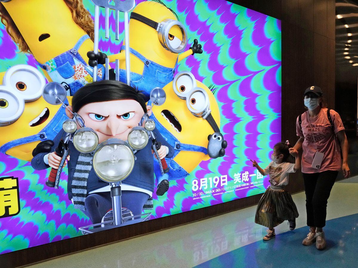 Visitors to a cinema showing Minions: The Rise Of Gru pass an advertisement for the film in Beijing