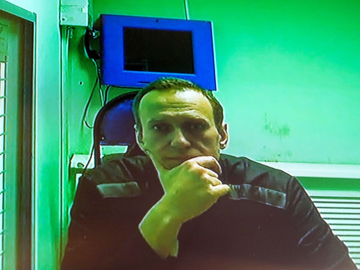 Russian opposition leader Alexei Navalny is seen on a television screen during his appearance in a video link provided by the Russian Federal Prison Service in the courtroom of the Second Appellate Court in Moscow, Russia, in October