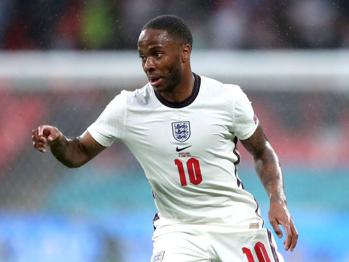  Raheem Sterling, wearing a white England jersey with the number 10, is about to take a penalty kick.
