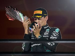 George Russell kisses the trophy