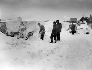 nostalgia pic. Wellington. nostalgia pic. Arleston. A car being dug out of heavy snow in April 1961. This picture was emailed in by David Thorp u534gold@gmail.com: "I took it in April 1961 at Hilltop Garage, where I was forced to spend the night.  I was on my way home to Little Dawley when I got stuck. Hilltop garage is on Dawley Road, Wellington, about four hundred yards on the left from the A5 traffic lights (Cock Inn). In those days it was a Repair garage (I believe they sell cars there now). I cannot for the life of me remember the name of the chap who ran the garage, but he was a good friend at the time. I  was working for BIP Chemicals (Birmingham) and was driving an Austin 1100 .  I managed to get up the hill as far as the Garage, and pulled into his yard.  I had snow chains on the car as it was front wheel drive (useless in snow) . Rear wheel drive is better because you can put a load of weight in the boot and then with front to rear weight transfer you have traction.  Best car in snow used to be the Beetle - rear engine.  I spent some time in the workshop but eventually when (Dave?) went to his bed I retired to the car where I kept the engine running on and off most of the night to keep the heater going after covering the radiator with a sack... I live at 17 Moorhouse Close, Wellington TF1 2BF 01952 251504". Wintry weather. Snowy weather. Winter scene. Winter scenes. Library code: Wellington nostalgia 2021. Arleston nostalgia 2021. ..