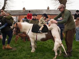 Two-year-old Clementine Soames with pony Horlicks and one of the hounds as riders gather for the annual Fernie Hunt Boxing Day meet in Leicestershire