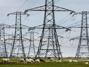 Overhead power cables from the Dungeness Nuclear Power Station stretching across the Kent countryside.