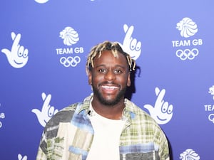 Myles Smith smiling in front of National Lottery and Team GB signage