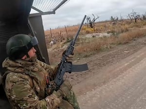 Russia soldier with gun on back of vehicle