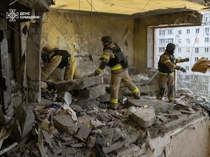 Rescuers searching a destroyed apartment block