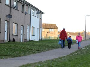 A family walking away from the camera in a housing estate