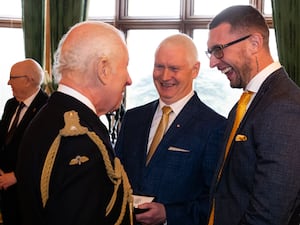 Charles shakes hands with two men