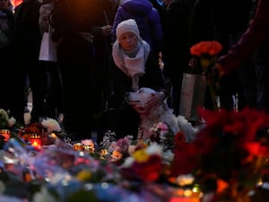 People pay tribute outside a church near the Christmas market where a car drove into a crowd on Friday evening in Magdeburg