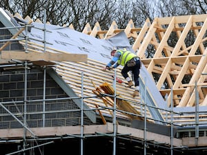 A workman on the roof of a building under construction