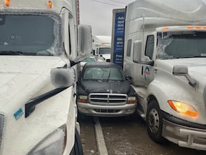 Car wedged between two trucks