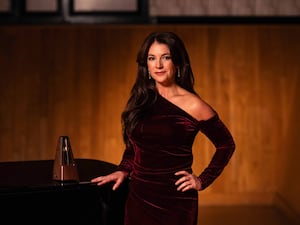 A woman posing in front of a piano