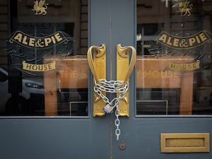 Chains secure the doors of a closed Fuller’s pub