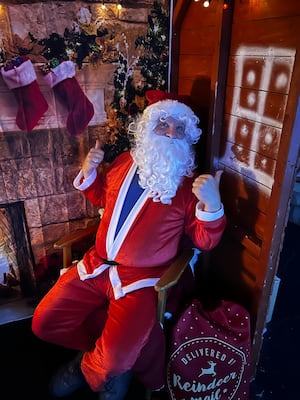 Santa in his grotto in Builth Wells greeting youngsters and giving them a gift.