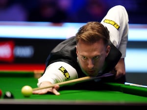 Judd Trump goes to play a shot