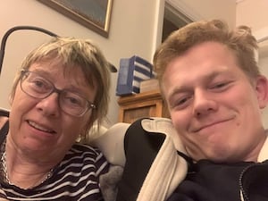 Man takes a selfie with his mother while sat on the sofa