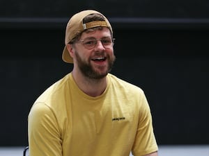 Jay McGuiness smiles while sat in a chair