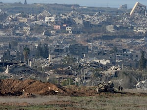 Israeli soldiers stand near a tank inside southern Gaza along the border with Israel