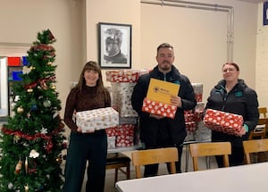 Ollie Locker and Jade Sutton from Wolves Foundation handing out presents to Lucy Cox from the Good Shepherd.