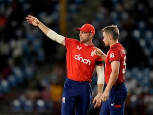 Jos Buttler, left, speaks to Sam Curran in England's T20 against the West Indies