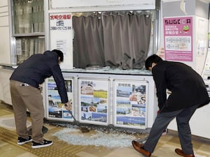 Two men clear up shattered glass