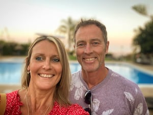 Craig and Lindsay Foreman smiling in front of a swimming pool