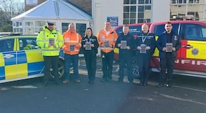 Staff holding leaflets as a road safety campaign targets young drivers and riders across local high schools.