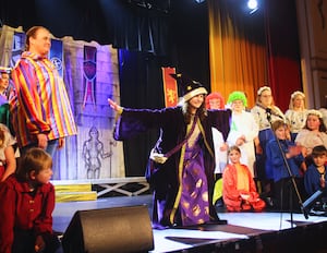 Merlin played by Jane Blees takes a bow watched by other cast members