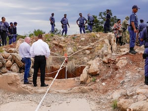 Police and security stand by a mineshaft