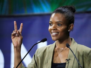 Candace Owens smiles and flashes a peace symbol