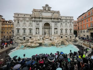 People admire the 18th century Trevi Fountain, one of Rome’s most famous landmarks, as it reopens to the public after undergoing maintenance