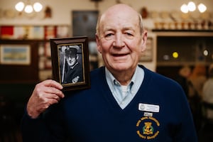 Chairman, Pete Bunting, with a picture of his younger self that hangs on the wall at Newport Navy Club