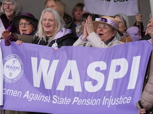 Women holding a purple banner at a Women Against State Pension Inequality protest outside the Scottish Parliament in Edinburgh, campaigning for justice and full compensation