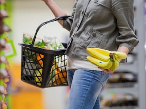 A supermarket shopper chooses a bunch of Fairtrade bananas.