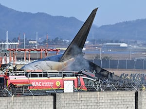 Firefighters and rescue team members work on the runway of Muan International Airport