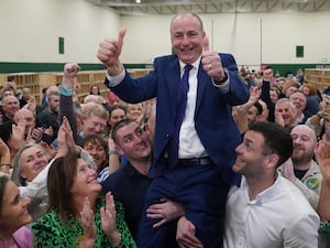 Fianna Fail leader Micheal Martin is hoisted up by his sons Cillian and Micheal Aodh