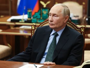 Russian President Vladimir Putin seated at a desk