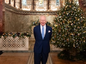 Charles poses before a Christmas tree