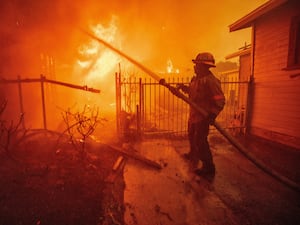 A firefighter battles the Eaton Fire in Altadena (Ethan Swope/AP)