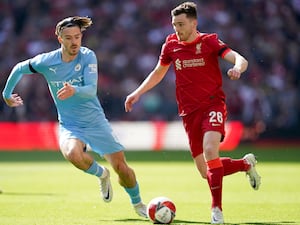 Liverpool’s Andy Robertson, right, takes on Manchester City’s Jack Grealish