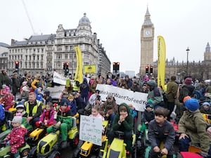 Children on toy tractors during a farmers protest in central London