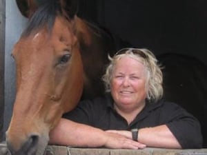 Wendy Buckney smiling next to a horse