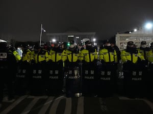 Police officers stand guard in front of the National Assembly in Seoul, South Korea