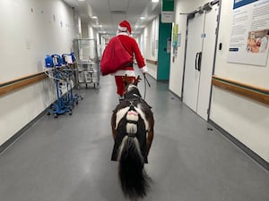 Tinkerbell follows Santa down a hospital corridor